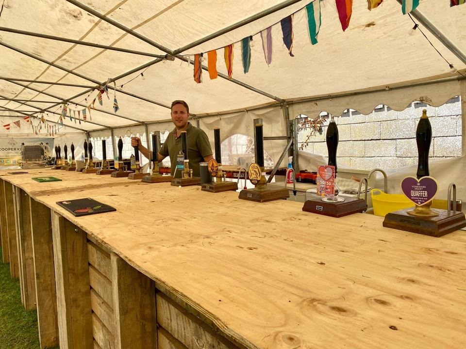 A festival bar under canvas, lined with hand-pulls