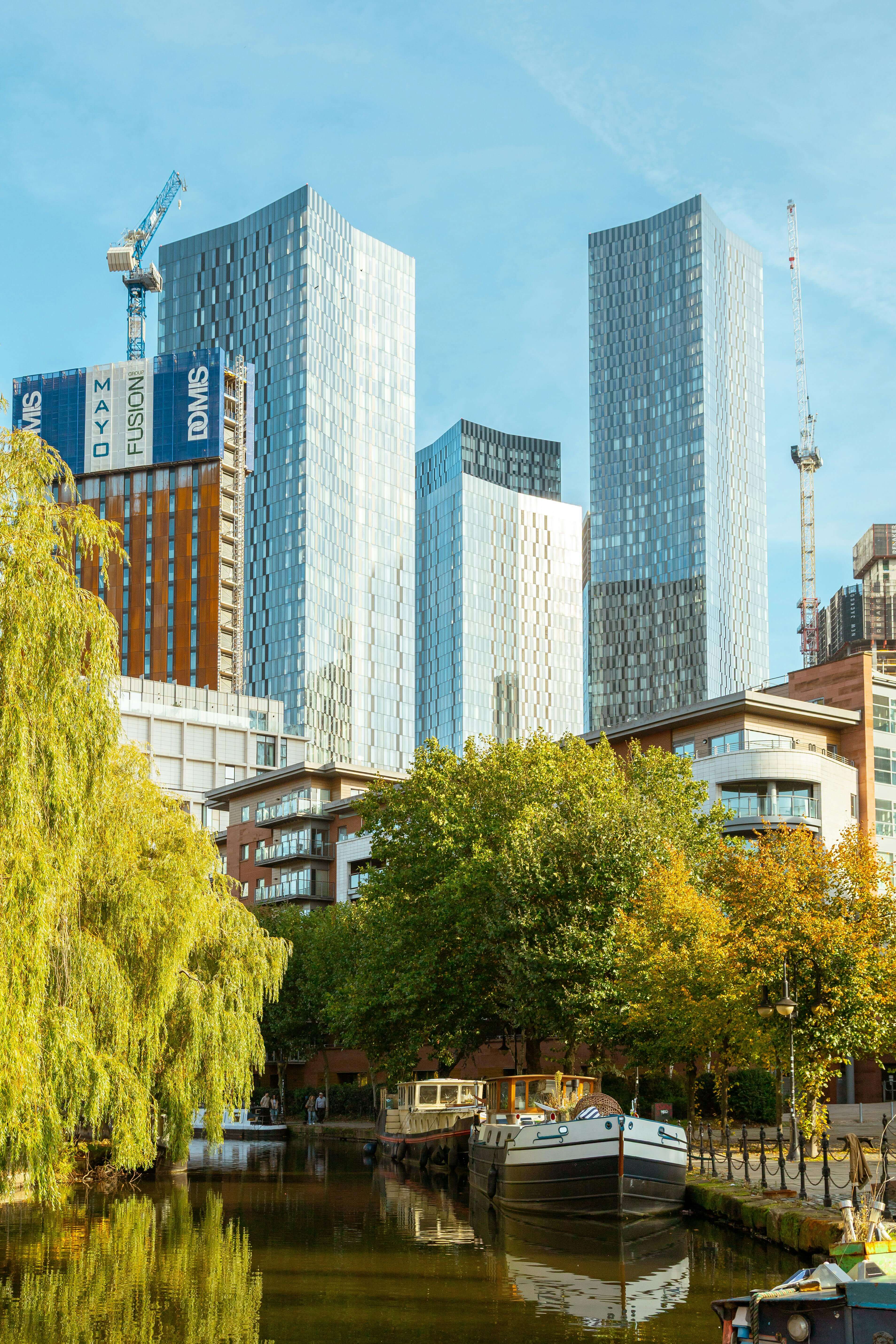 Manchester Castlefield canal basin with modern Deansgate skyscrapers and narrowboats