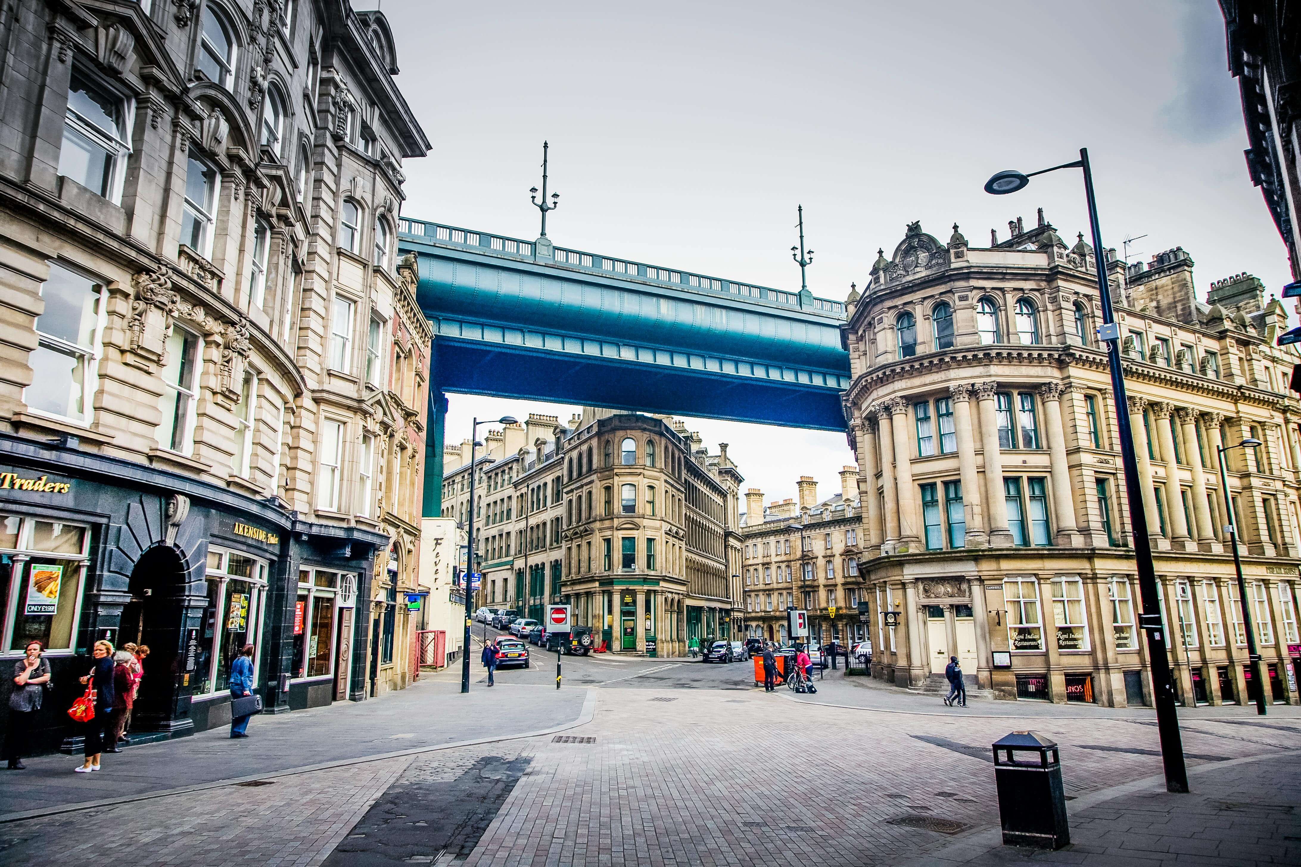 Blue elevated walkway spanning Newcastle city centre street with Victorian buildings