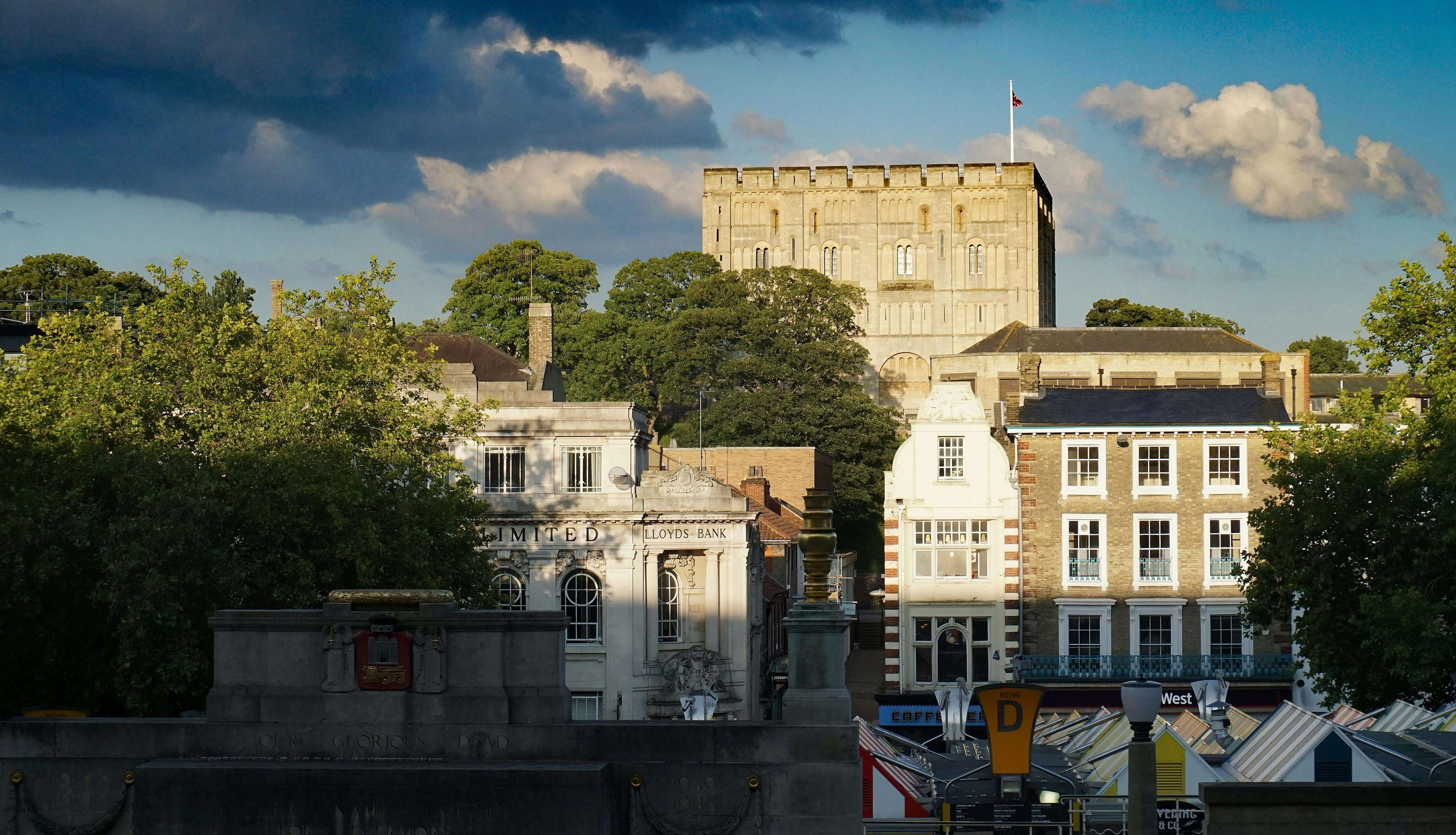 Norwich Castle keep towering above city centre buildings and market