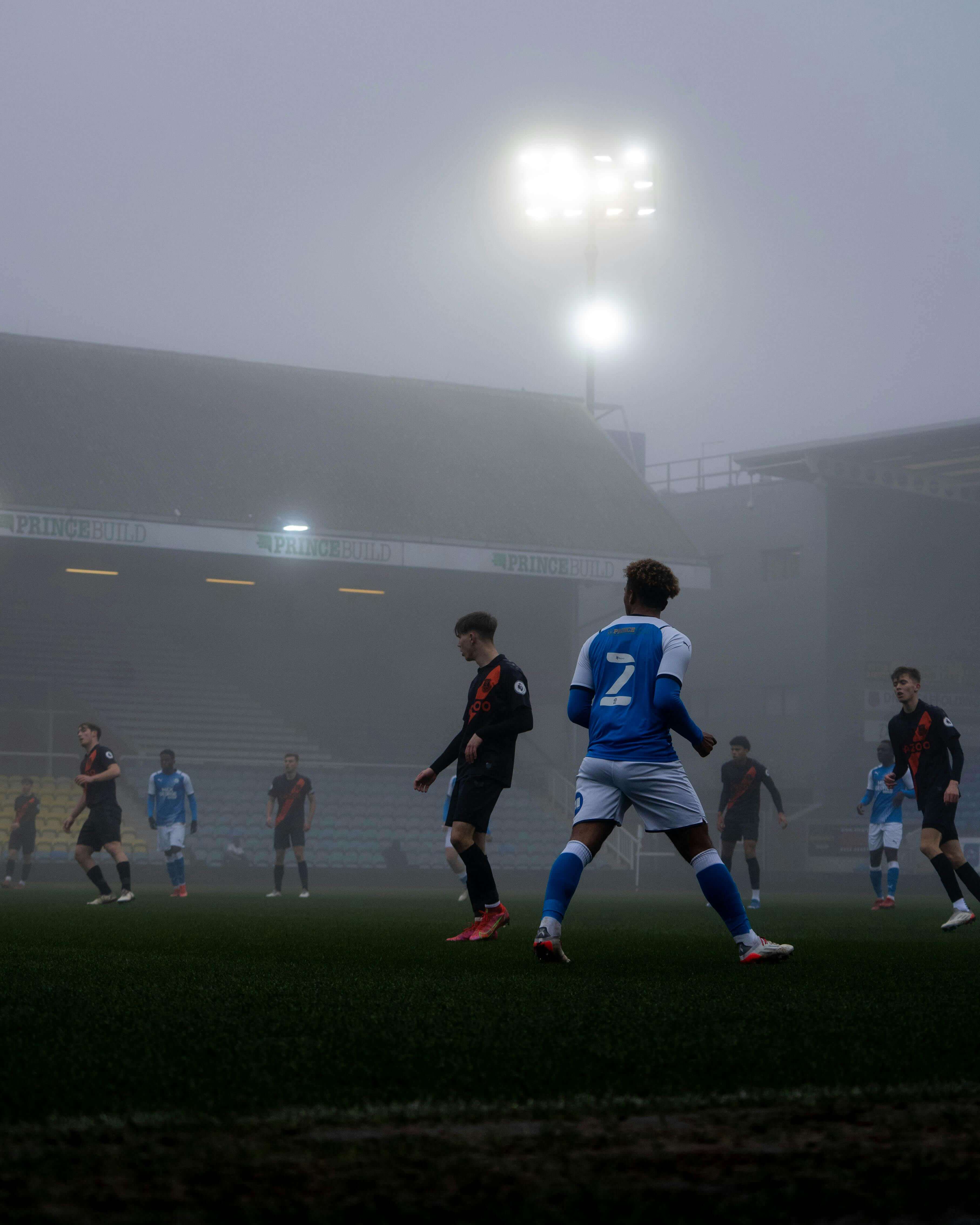 Football match at Peterborough United's stadium in atmospheric fog and floodlights