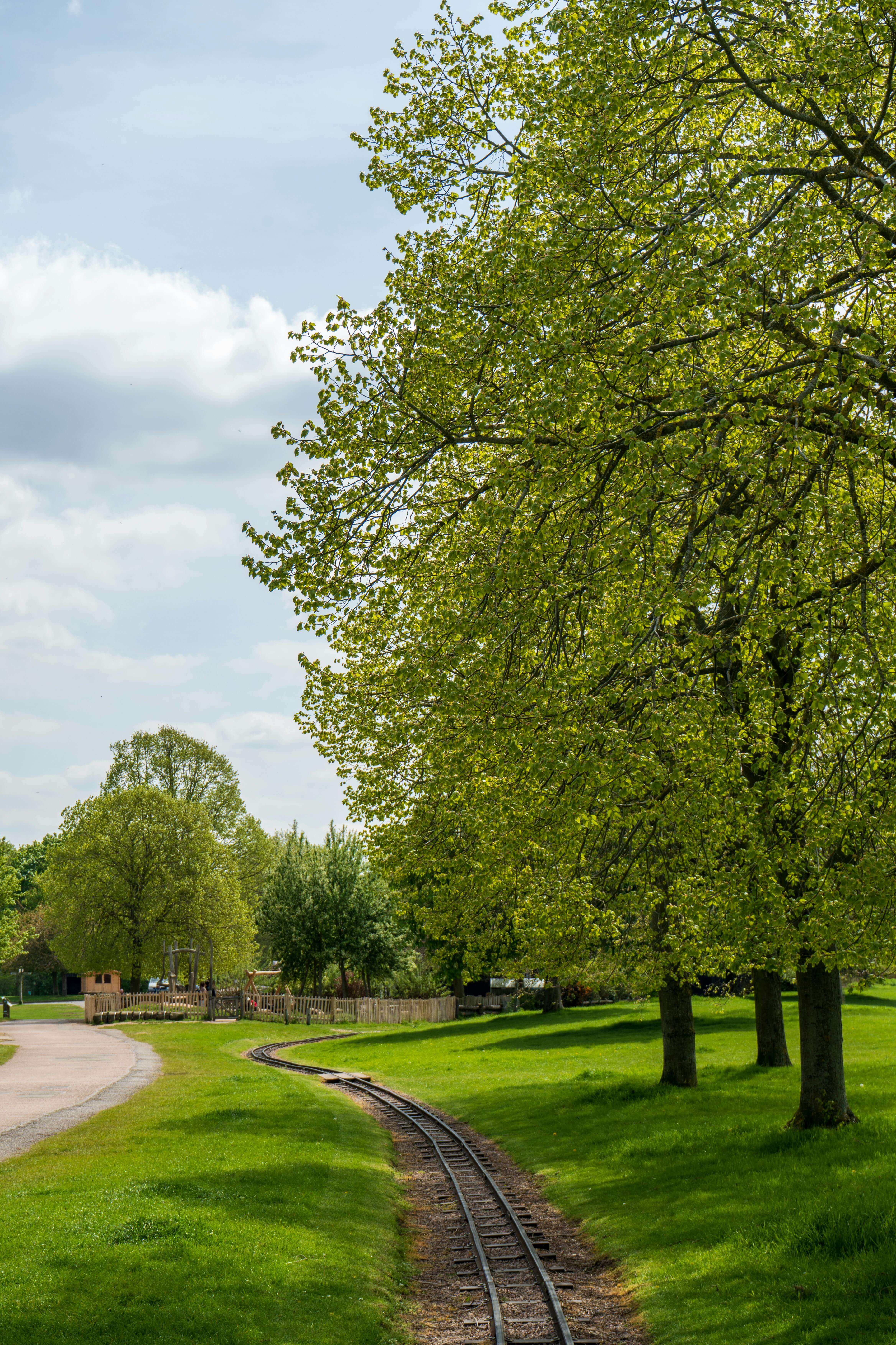 Miniature railway track curving through green parkland in Peterborough